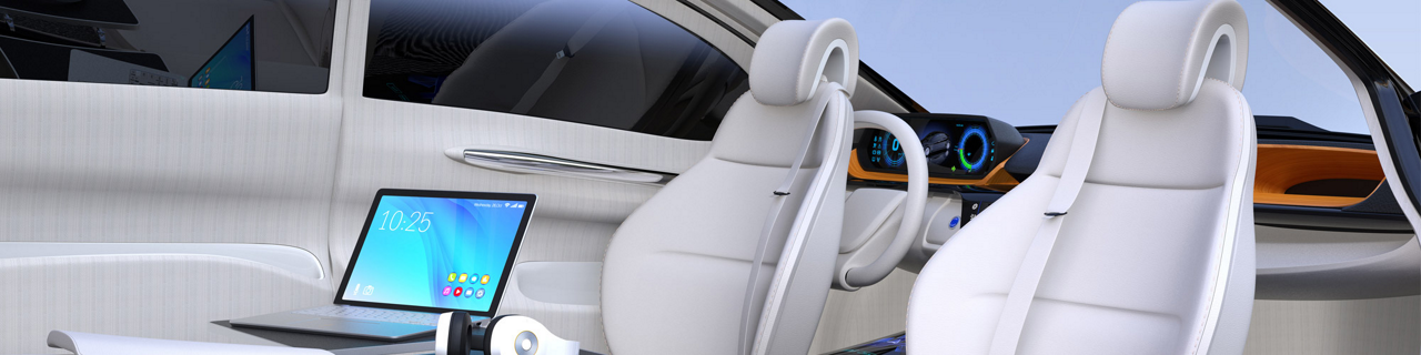 Open laptop next to swiveled front seats on inside of elegant car.