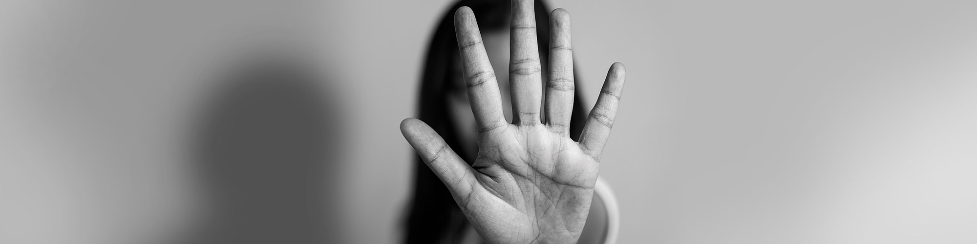 black and white image of a person holding their hand up to stop hate and violence