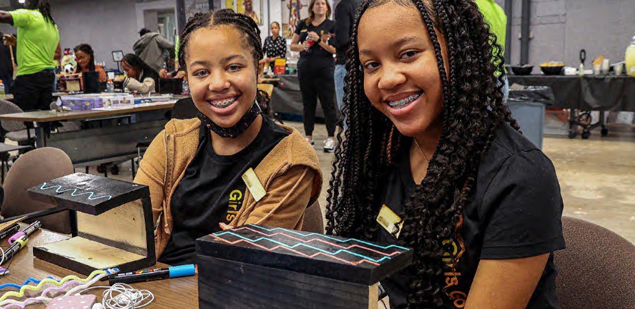 Two young girls sitting together at a Micron Girls Going Tech Event.