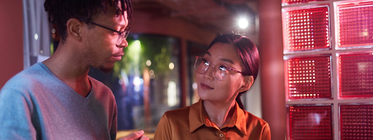 Two coworkers standing together in conversation  
