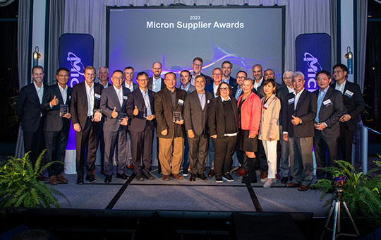 supplier-awards-page-blog-2000x500.jpg: partners in front of "Micron Supplier Awards" and vertical Micron banners