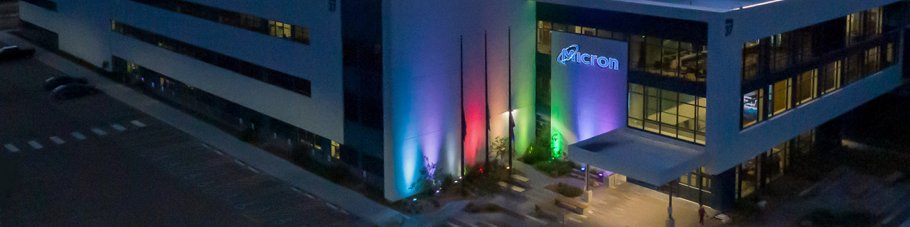 Micron building at night illuminated with rainbow colors